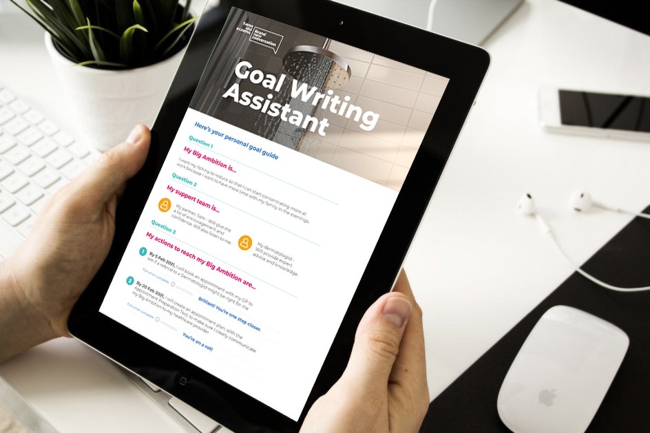 Close-up of a tablet being held by two hands with the Goal Setting Assistant tool displayed on screen